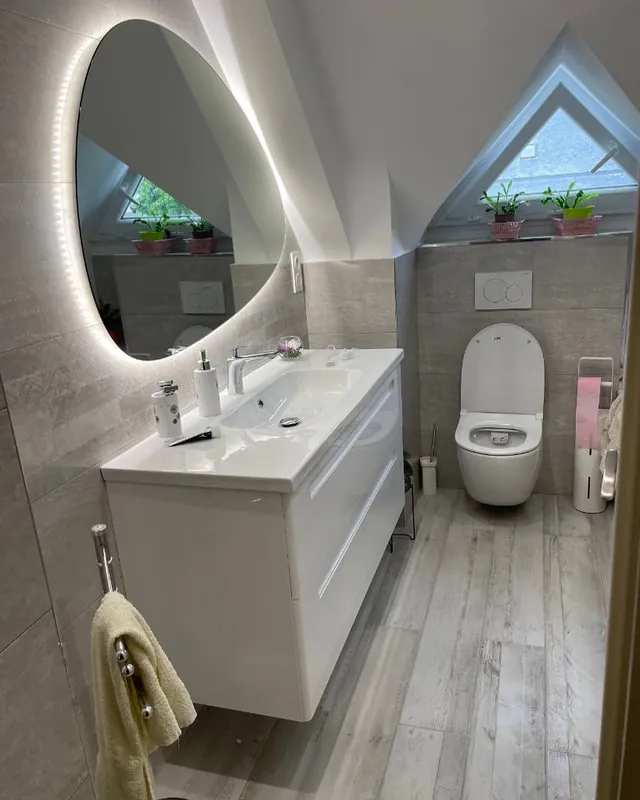 Salle de bain refaite avec miroir LED et baignoire, dans un pavillon